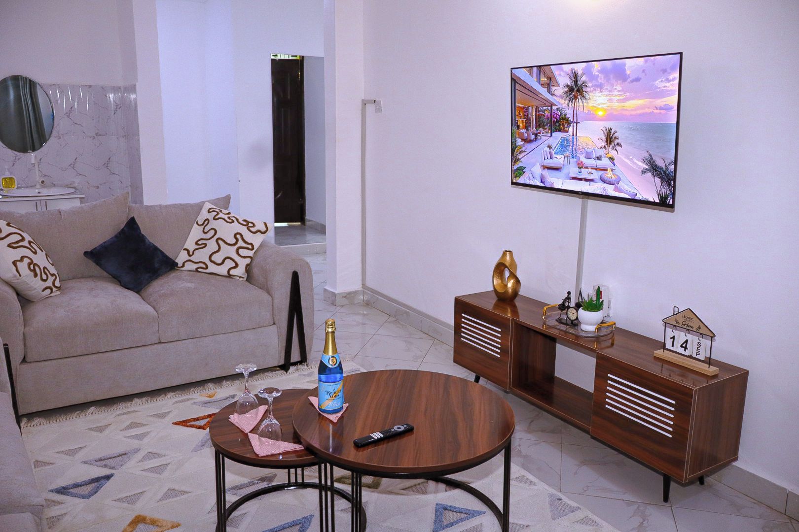 A living room with a sofa, a coffee table, a TV, and a decorative item on a console table.