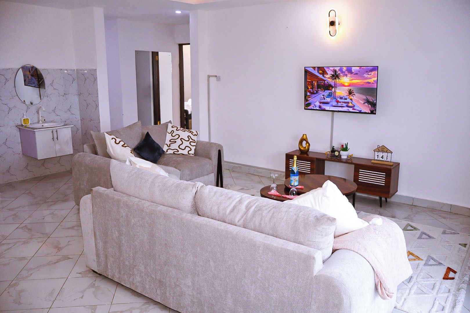 Ein modernes Wohnzimmer mit einer Couch, einem Fernseher und einem Wandbild.