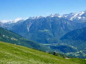 Eine gebirgige Landschaft mit einem Tal und einer kleinen Siedlung.