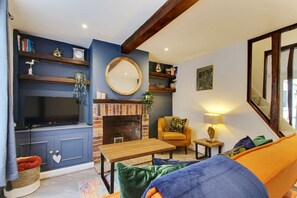 A living room with a fireplace, a television, and a sofa.