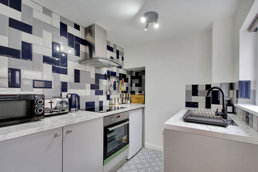Une cuisine moderne équipée d’un four à micro-ondes, d’un grille-pain et d’un four traditionnel.