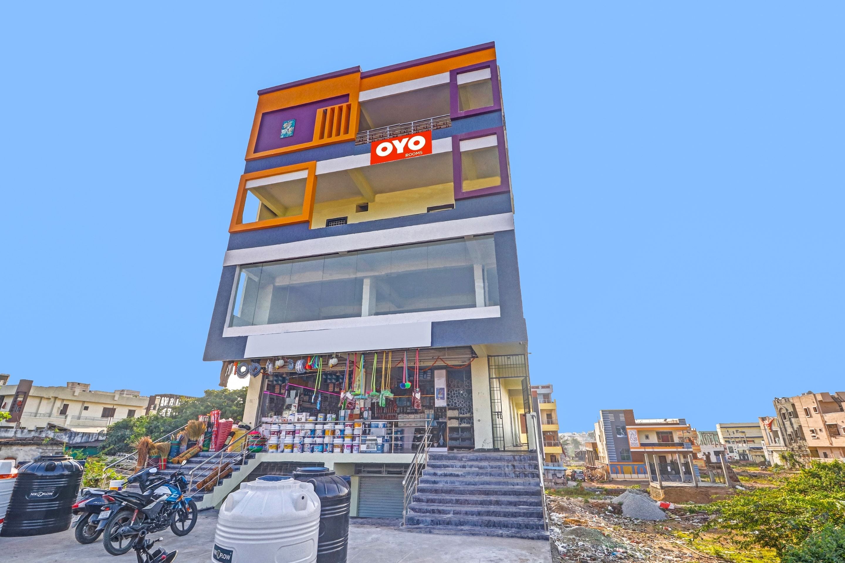 A multi-story building with a prominent 'OYO' sign, featuring a staircase leading to the entrance.