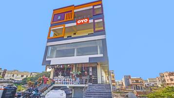 A multi-story building with a prominent 'OYO' sign, featuring a staircase leading to the entrance.