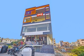 A multi-story building with a prominent 'OYO' sign, featuring a staircase leading to the entrance. - Super Hotel O Elite Stay (Hyderabad)
