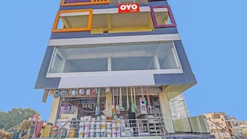 Un edificio de varios pisos con un letrero que indica 'OYO ROOMS', señalando que se trata de un hotel.