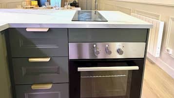 A kitchen with a built-in oven and a countertop with a glass top.