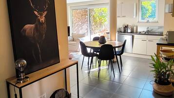Une cuisine moderne avec un coin repas, une grande fenêtre et un ventilateur de plafond.