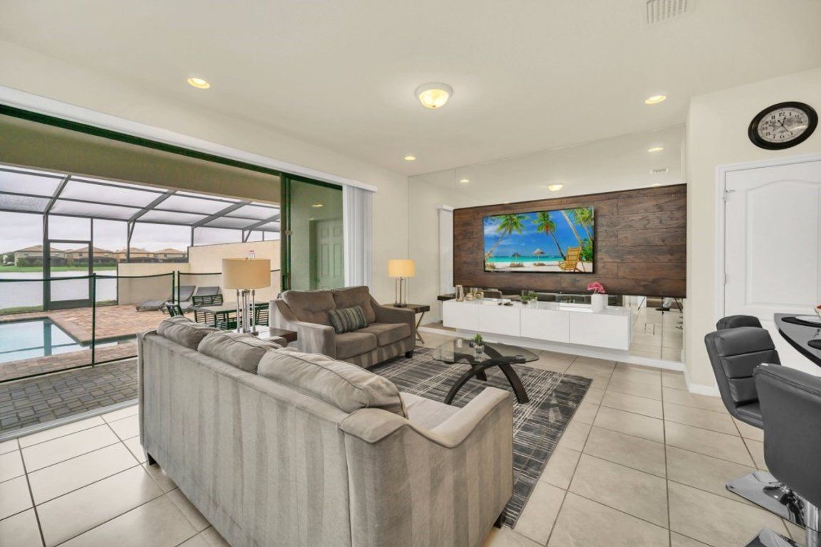 A modern living room with a sofa, a coffee table, and a TV mounted on a wooden wall.