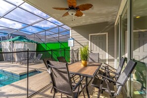 A covered patio area with a pool, outdoor furniture, and a ceiling fan. - Windsor Island - 34516 (Davenport)