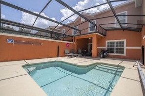 An outdoor swimming pool with a covered patio area, lounge chairs, and a view of a residential building. - Paradise Palms - 34694 (Kissimmee)