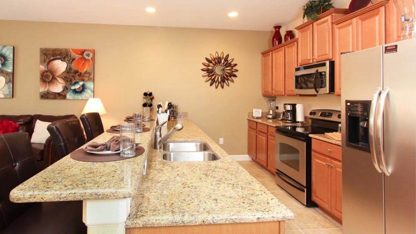 A kitchen with granite countertops, stainless steel appliances, and wooden cabinets.