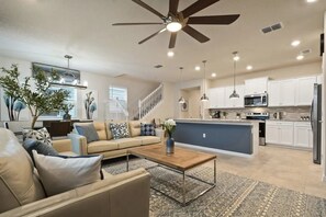 A modern living room with a sofa, coffee table, and a ceiling fan. - Windsor Island - 6336 (Davenport)