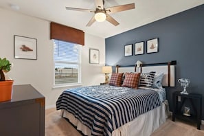 A bedroom with a bed, a ceiling fan, a window with blinds, and framed pictures on the wall. - Windsor Island - 6336 (Davenport)