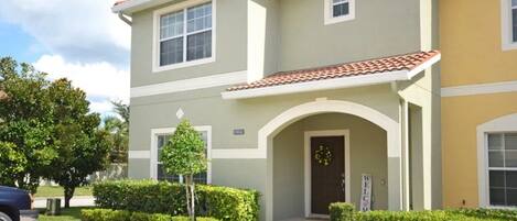 A two-story building with a welcoming entrance, a small tree, and well-maintained landscaping.