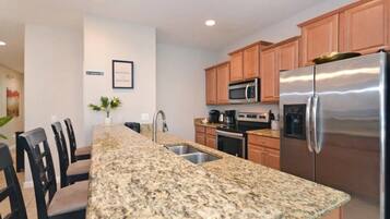 A kitchen with granite countertops, stainless steel appliances, and wooden cabinets.