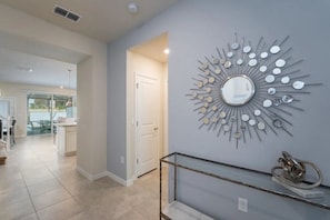 A modern interior with a decorative wall piece, a glass shelf, and a view into another room. - Windsor Island - 6482 (Davenport)