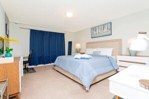 Ein Hotelzimmer mit Bett, Schreibtisch, Stuhl und einem Bild an der Wand.