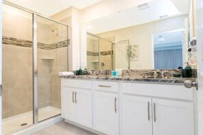 A bathroom with a glass shower enclosure, white cabinets, and a marble countertop. - Solara Resort - 6766 (Kissimmee)