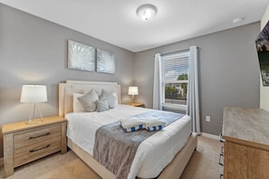 A bedroom with a bed, bedside tables, a window with blinds, and artwork on the wall. - Windsor Island - 7358 (Davenport)