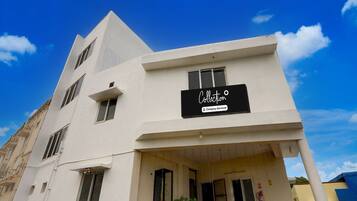 A modern two-story building with a sign indicating it is a company-serviced collection.