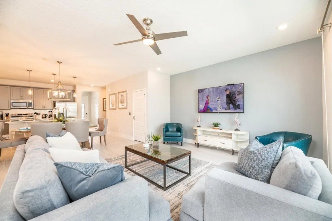 A modern living room with a sofa, coffee table, and a ceiling fan.