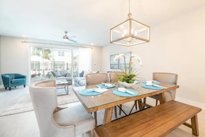Un comedor con una mesa de madera, individuales azules y una planta en maceta.