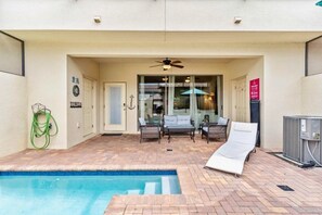 An outdoor swimming pool area with lounge chairs and a ceiling fan. - Windsor at Westside - 25962 (Kissimmee)