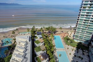 A resort with multiple swimming pools, a beach, and a view of the ocean. - Luxury Oceanfront Corner Condo | Icon Vallarta (Puerto Vallarta)