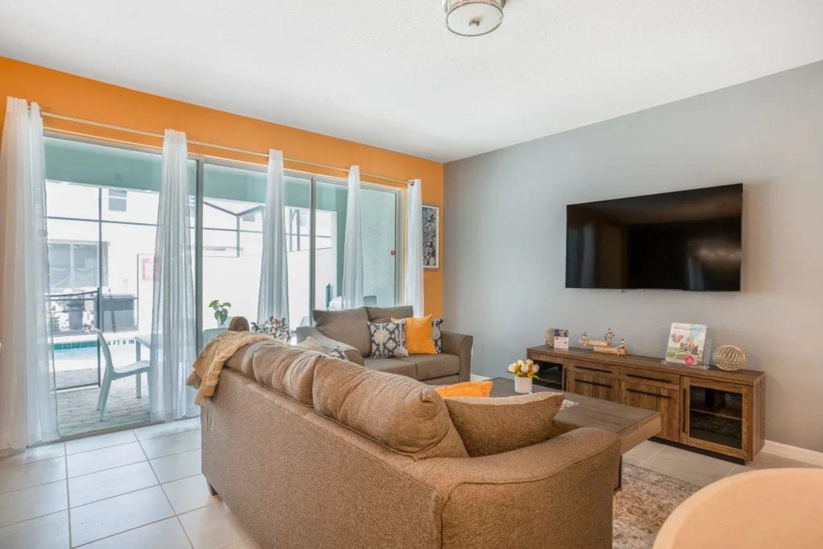 A living room with a sofa, a television, and a cabinet.