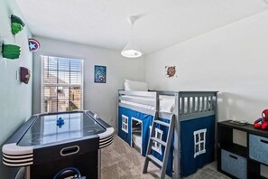 A child's room with bunk beds, a play table, and superhero decorations. - Solara Resort - 29170 (Kissimmee)