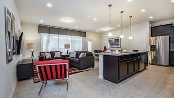 A modern kitchen with a central island, built-in cabinets, and stainless steel appliances.