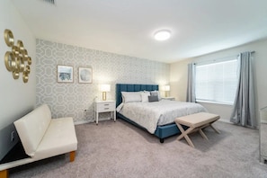 A bedroom with a bed, bedside tables, a chair, and a window with curtains. - Solara Resort - 6112 (Kissimmee)