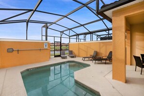 An indoor swimming pool with a glass ceiling, surrounded by lounge chairs and a view of the outdoors. - Paradise Palms - 6135 (Kissimmee)