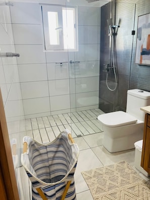 A modern bathroom with a glass shower enclosure, a toilet, and a sink. - Sun, Pool & Sand! 3BR Family Villa Near the Beach (Cabarete)