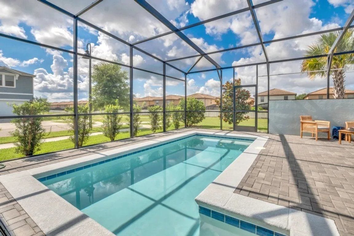 A swimming pool with a clear view of the sky and surrounding houses.