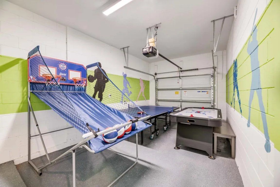 Une salle de sport équipée d’un terrain de basket-ball, d’une table de ping-pong et d’une table de tennis de table.