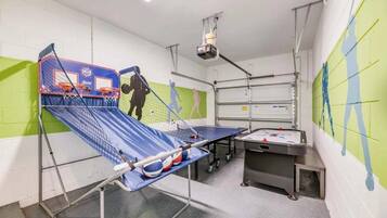 Une salle de sport équipée d’un terrain de basket-ball, d’une table de ping-pong et d’une table de tennis de table.
