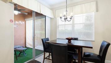 A dining area with a table, chairs, and a chandelier.