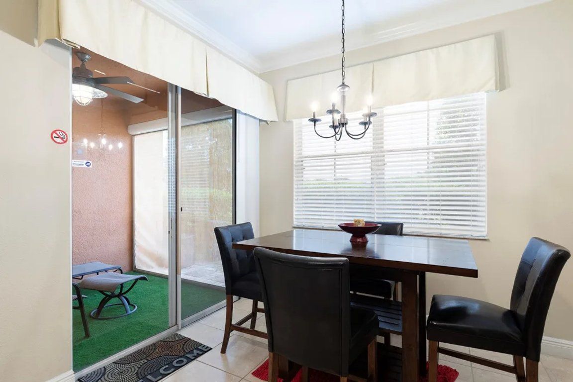 A dining area with a table, chairs, and a chandelier.