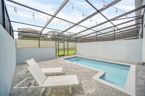An outdoor swimming pool with a glass ceiling, surrounded by a brick patio and white lounge chairs. - Windsor Island - 24627 (Davenport)