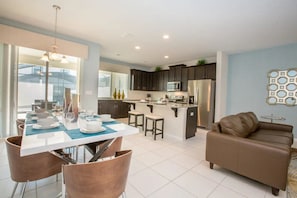 A modern kitchen with dark cabinets, a central island, and stainless steel appliances. - Solara Resort - 25995 (Kissimmee)