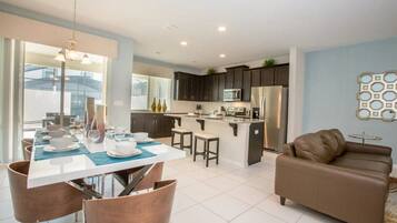 A modern kitchen with dark cabinets, a central island, and stainless steel appliances.