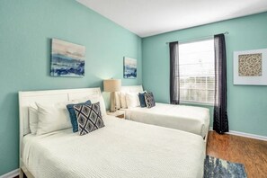 A room with two beds, a window with curtains, and artwork on the walls. - Vista Cay - 28755 (Orlando)