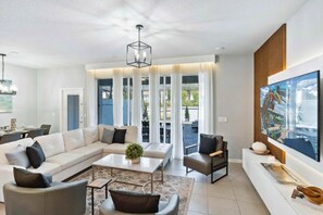 A modern living room with a sectional sofa, a coffee table, and a television on a stand. - Windsor Island - 29337 (Davenport)