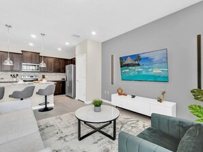 A modern kitchen with dark cabinets, a white countertop, and stainless steel appliances. - Windsor Island - 33034 (Davenport)