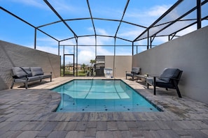 A covered outdoor swimming pool with lounge chairs and a basketball hoop. - Solara Resort - 34618 (Kissimmee)