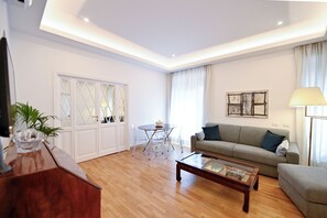 A modern living room with a sofa, coffee table, and a dining area with chairs. - Three steps from Spanish Steps, Via Veneto, and Villa Borghese (ROMA - RM)