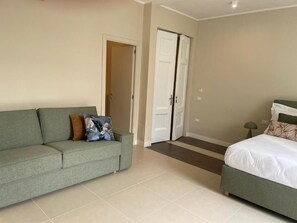 Un dormitorio con una cama, un sofá y una puerta.