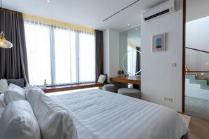 Una habitación de hotel moderna con una cama grande, un escritorio, un espejo y una escalera.