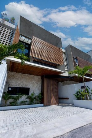 Un edificio moderno de varios pisos con techo plano, ventanas amplias y fachada de piedra.
